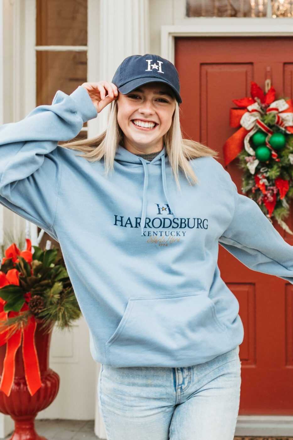 Girl wearing a Harrodsburg branded cap and hoodie