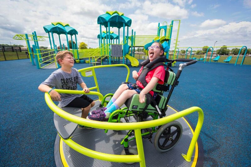 Kids on playground equipment adapted for wheel chair